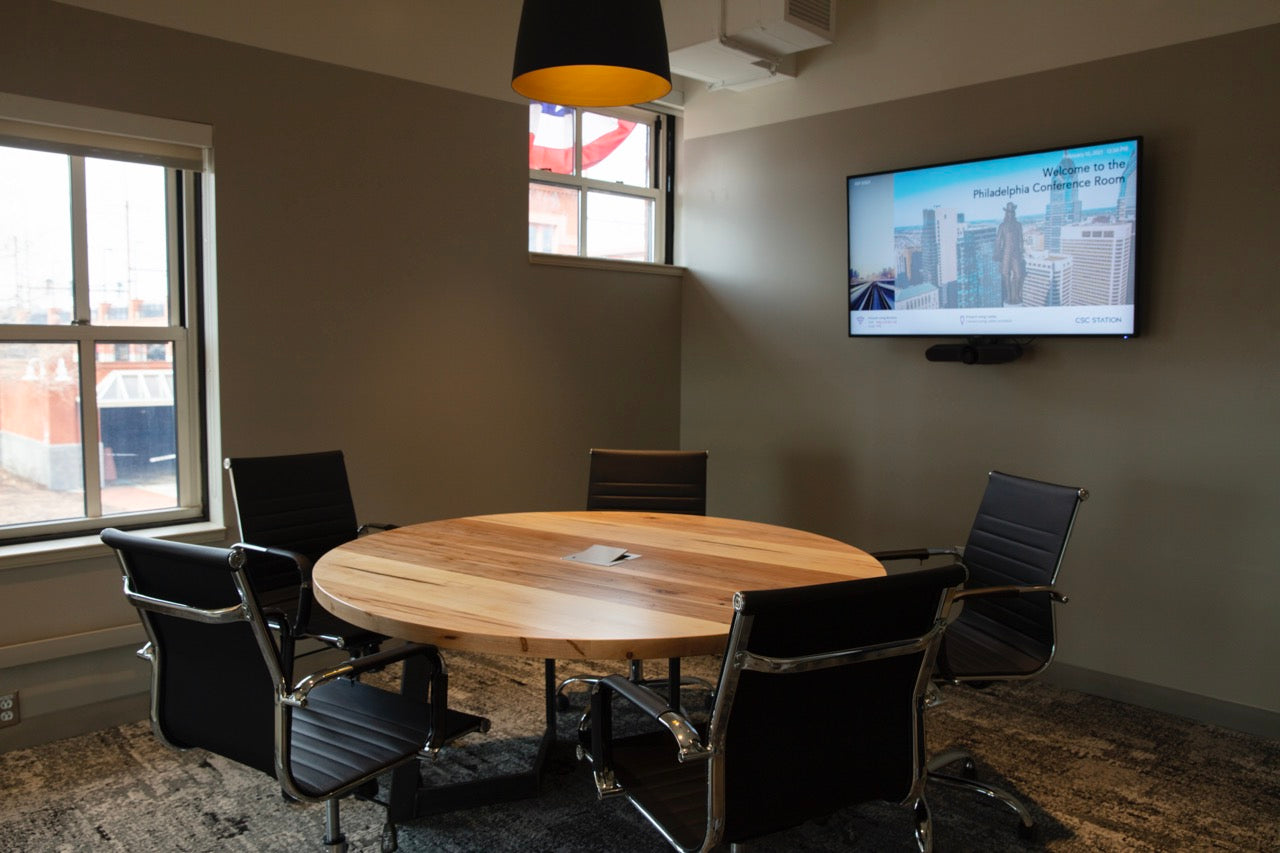 Round wooden conference table with metal legs