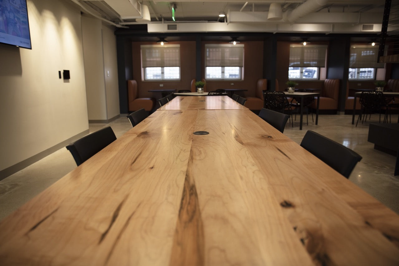Very long light wood conference table in office space